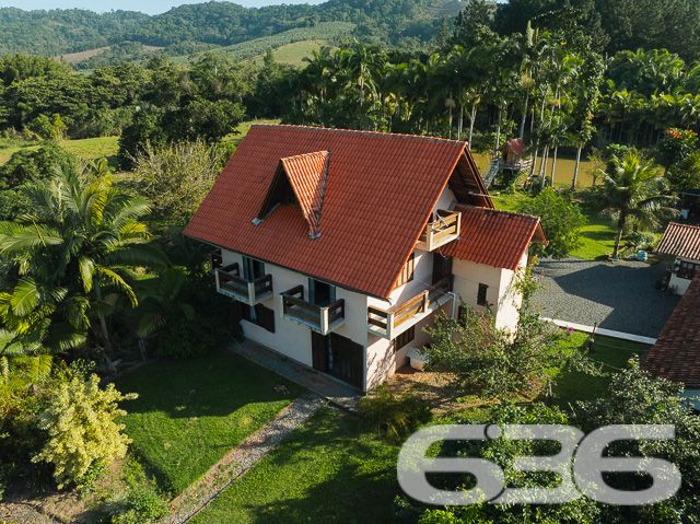 Apresentamos uma oportunidade excepcional para quem busca tranquilidade e conforto em um ambiente naturalmente deslumbrante. Este sítio localizado em São João do Itaperiú, SC, oferece uma área total de 100.000 m² de terreno plano, envolto em uma paisagem exuberante e benfeitorias que elevam a qualidade de vida no campo.

A chácara é composta por três residências, garantindo flexibilidade para hospedagem de familiares ou como potencial fonte de renda com locação. A casa principal é uma joia arquitetônica, com três pavimentos no estilo colonial, incluindo uma suíte master e mais uma suíte, ambos ricamente detalhados com madeira nobre de itaúba em portas, janelas e sacadas. Aquecimento solar e água de poço artesiano asseguram conforto e sustentabilidade.

As áreas de convivência são amplas e acolhedoras, com duas salas espaçosas, cozinha prática e lavabo, tudo sob a cobertura majestosa que confere charme e elegância ao ambiente. A propriedade também inclui uma segunda casa com dois quartos e uma cozinha conjugada com a sala, e uma terceira casa em fase de finalização, prometendo ainda mais espaço e comodidade.

Para os amantes do lazer ao ar livre, a chácara oferece uma piscina imersa na natureza, áreas de festa com churrasqueira e fogão a lenha, perfeitas para receber amigos e familiares. O terreno é adornado por um belo jardim, um pomar diversificado com várias frutíferas e até um ribeirão com nascente própria, além de dois tanques de peixes, ideal para os entusiastas da pesca.

Esta propriedade não é apenas uma casa, é um estilo de vida. Imersa em uma área com preservação legal, ela oferece privacidade, conforto e a infinita possibilidade de criar momentos inesquecíveis. Entre o canto dos pássaros e o murmurar das águas, o sítio é um convite para viver seus dias com mais plenitude e paz.

Venha conhecer seu novo lar no campo, onde cada amanhecer traz a promessa de um novo começo. Aguardamos seu contato para agendar uma visita e experimentar em primeira mão a beleza e tranquilidade que só a 636 Negócios Imobiliários pode oferecer.
 
636 NEGÓCIOS IMOBILIÁRIOS: A SUA MELHOR ESCOLHA
Com mais de 30 anos de experiência, a 636 Negócios Imobiliários é sua parceira ideal para encontrar o imóvel perfeito. Estamos prontos para ajudá-lo a fazer deste imóvel o seu novo lar.
 
Telefone: (47) 3451-0636
WhatsApp: (47) 99190-0636
 
Não perca esta oportunidade única. Visite nosso site para mais informações: i636.com.br