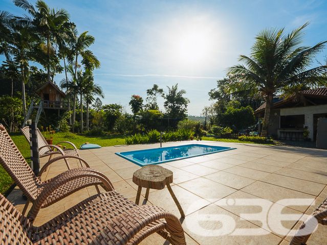 Apresentamos uma oportunidade excepcional para quem busca tranquilidade e conforto em um ambiente naturalmente deslumbrante. Este sítio localizado em São João do Itaperiú, SC, oferece uma área total de 100.000 m² de terreno plano, envolto em uma paisagem exuberante e benfeitorias que elevam a qualidade de vida no campo.

A chácara é composta por três residências, garantindo flexibilidade para hospedagem de familiares ou como potencial fonte de renda com locação. A casa principal é uma joia arquitetônica, com três pavimentos no estilo colonial, incluindo uma suíte master e mais uma suíte, ambos ricamente detalhados com madeira nobre de itaúba em portas, janelas e sacadas. Aquecimento solar e água de poço artesiano asseguram conforto e sustentabilidade.

As áreas de convivência são amplas e acolhedoras, com duas salas espaçosas, cozinha prática e lavabo, tudo sob a cobertura majestosa que confere charme e elegância ao ambiente. A propriedade também inclui uma segunda casa com dois quartos e uma cozinha conjugada com a sala, e uma terceira casa em fase de finalização, prometendo ainda mais espaço e comodidade.

Para os amantes do lazer ao ar livre, a chácara oferece uma piscina imersa na natureza, áreas de festa com churrasqueira e fogão a lenha, perfeitas para receber amigos e familiares. O terreno é adornado por um belo jardim, um pomar diversificado com várias frutíferas e até um ribeirão com nascente própria, além de dois tanques de peixes, ideal para os entusiastas da pesca.

Esta propriedade não é apenas uma casa, é um estilo de vida. Imersa em uma área com preservação legal, ela oferece privacidade, conforto e a infinita possibilidade de criar momentos inesquecíveis. Entre o canto dos pássaros e o murmurar das águas, o sítio é um convite para viver seus dias com mais plenitude e paz.

Venha conhecer seu novo lar no campo, onde cada amanhecer traz a promessa de um novo começo. Aguardamos seu contato para agendar uma visita e experimentar em primeira mão a beleza e tranquilidade que só a 636 Negócios Imobiliários pode oferecer.
 
636 NEGÓCIOS IMOBILIÁRIOS: A SUA MELHOR ESCOLHA
Com mais de 30 anos de experiência, a 636 Negócios Imobiliários é sua parceira ideal para encontrar o imóvel perfeito. Estamos prontos para ajudá-lo a fazer deste imóvel o seu novo lar.
 
Telefone: (47) 3451-0636
WhatsApp: (47) 99190-0636
 
Não perca esta oportunidade única. Visite nosso site para mais informações: i636.com.br