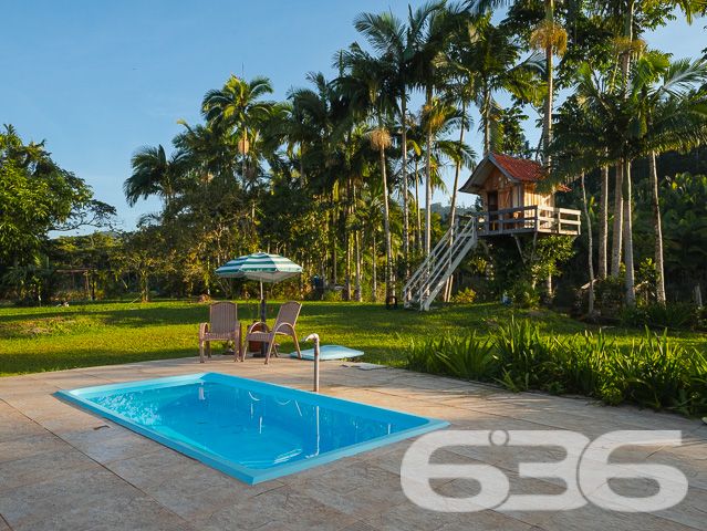 Apresentamos uma oportunidade excepcional para quem busca tranquilidade e conforto em um ambiente naturalmente deslumbrante. Este sítio localizado em São João do Itaperiú, SC, oferece uma área total de 100.000 m² de terreno plano, envolto em uma paisagem exuberante e benfeitorias que elevam a qualidade de vida no campo.

A chácara é composta por três residências, garantindo flexibilidade para hospedagem de familiares ou como potencial fonte de renda com locação. A casa principal é uma joia arquitetônica, com três pavimentos no estilo colonial, incluindo uma suíte master e mais uma suíte, ambos ricamente detalhados com madeira nobre de itaúba em portas, janelas e sacadas. Aquecimento solar e água de poço artesiano asseguram conforto e sustentabilidade.

As áreas de convivência são amplas e acolhedoras, com duas salas espaçosas, cozinha prática e lavabo, tudo sob a cobertura majestosa que confere charme e elegância ao ambiente. A propriedade também inclui uma segunda casa com dois quartos e uma cozinha conjugada com a sala, e uma terceira casa em fase de finalização, prometendo ainda mais espaço e comodidade.

Para os amantes do lazer ao ar livre, a chácara oferece uma piscina imersa na natureza, áreas de festa com churrasqueira e fogão a lenha, perfeitas para receber amigos e familiares. O terreno é adornado por um belo jardim, um pomar diversificado com várias frutíferas e até um ribeirão com nascente própria, além de dois tanques de peixes, ideal para os entusiastas da pesca.

Esta propriedade não é apenas uma casa, é um estilo de vida. Imersa em uma área com preservação legal, ela oferece privacidade, conforto e a infinita possibilidade de criar momentos inesquecíveis. Entre o canto dos pássaros e o murmurar das águas, o sítio é um convite para viver seus dias com mais plenitude e paz.

Venha conhecer seu novo lar no campo, onde cada amanhecer traz a promessa de um novo começo. Aguardamos seu contato para agendar uma visita e experimentar em primeira mão a beleza e tranquilidade que só a 636 Negócios Imobiliários pode oferecer.
 
636 NEGÓCIOS IMOBILIÁRIOS: A SUA MELHOR ESCOLHA
Com mais de 30 anos de experiência, a 636 Negócios Imobiliários é sua parceira ideal para encontrar o imóvel perfeito. Estamos prontos para ajudá-lo a fazer deste imóvel o seu novo lar.
 
Telefone: (47) 3451-0636
WhatsApp: (47) 99190-0636
 
Não perca esta oportunidade única. Visite nosso site para mais informações: i636.com.br